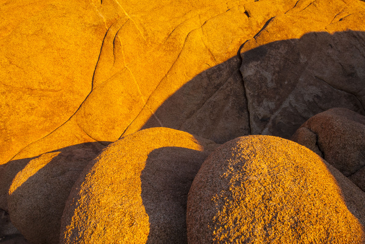 This cluster of round boulders against a larger rocky slope, accented by evening light to highlight the shapes and textures...