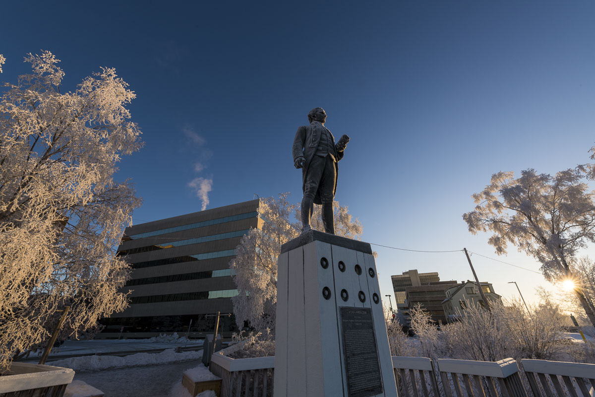 A stoic Captain James Cook stands amidst frosty trees in Resolution Park in downtown Anchorage.