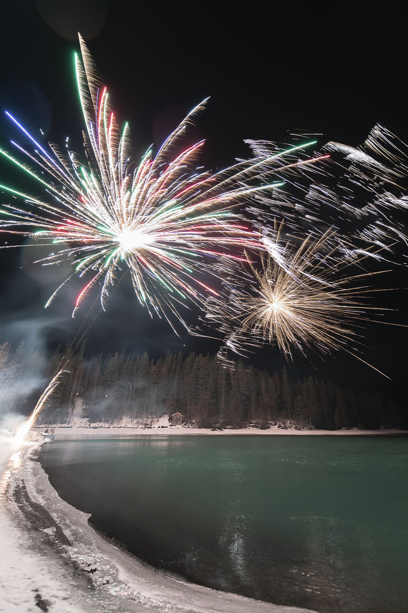 Fireworks erupt over the Kenai River at a private party on New Year's Eve, with wind blowing the sparks.