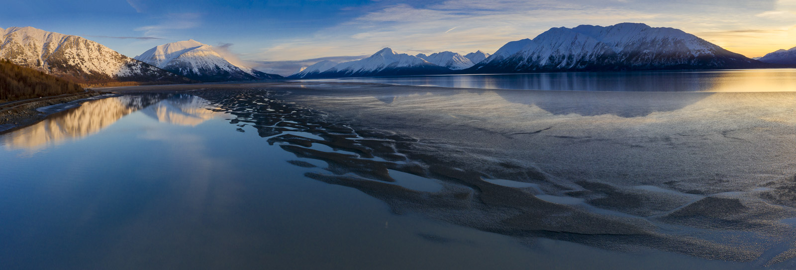 A bar of mudflats is exposed as the tide starts to recede on the Turnagain Arm on a winter evening.