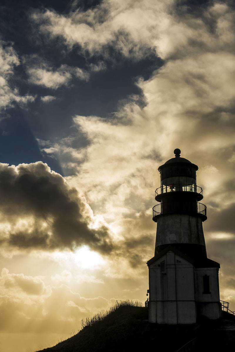 The Cape Disappointment Lighthouse, located on the Washington side of the mouth of the Columbia River, stands silhouetted against...