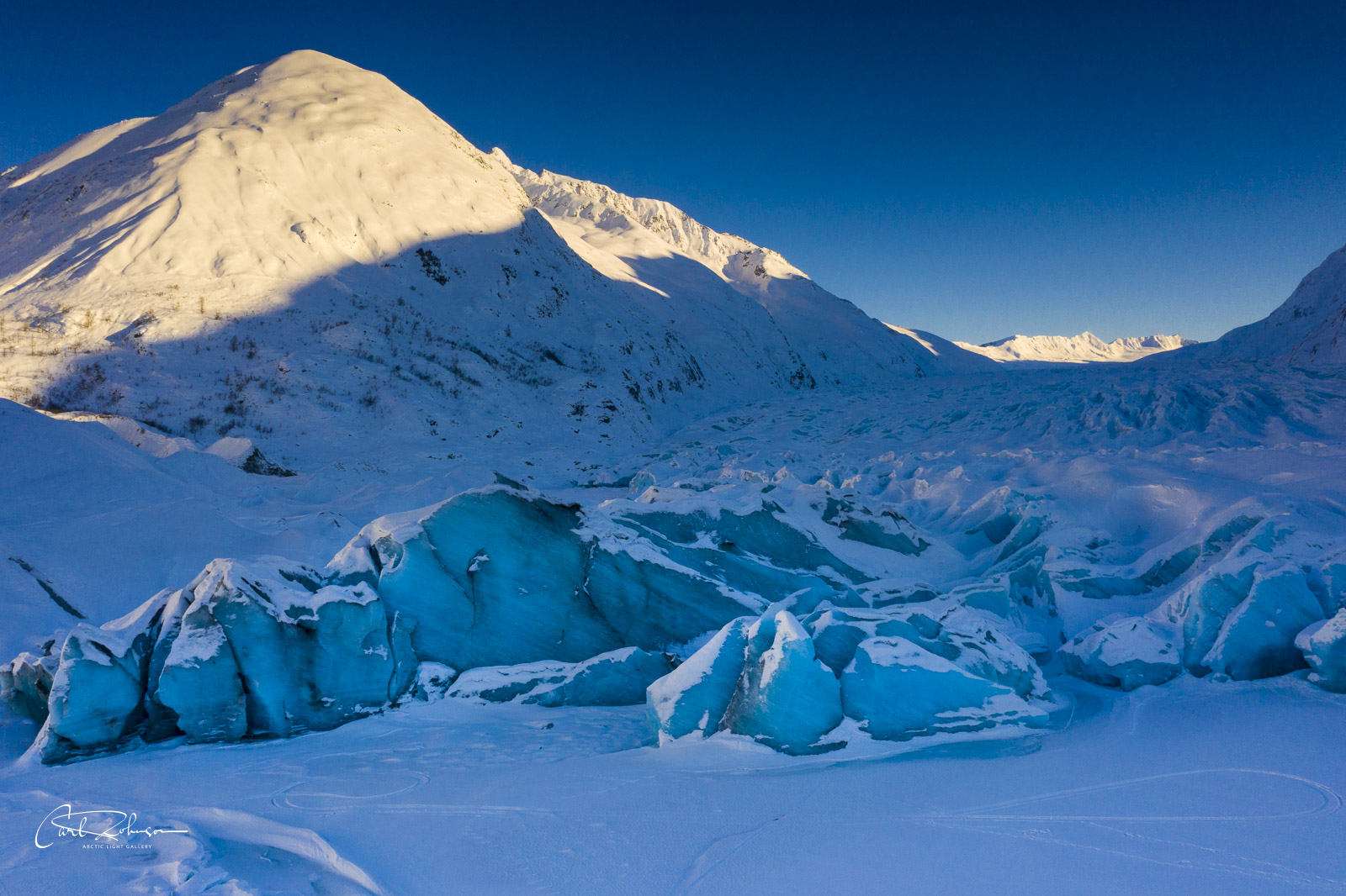 Evening light shines on a mountain peak behind Spencer Glacier.