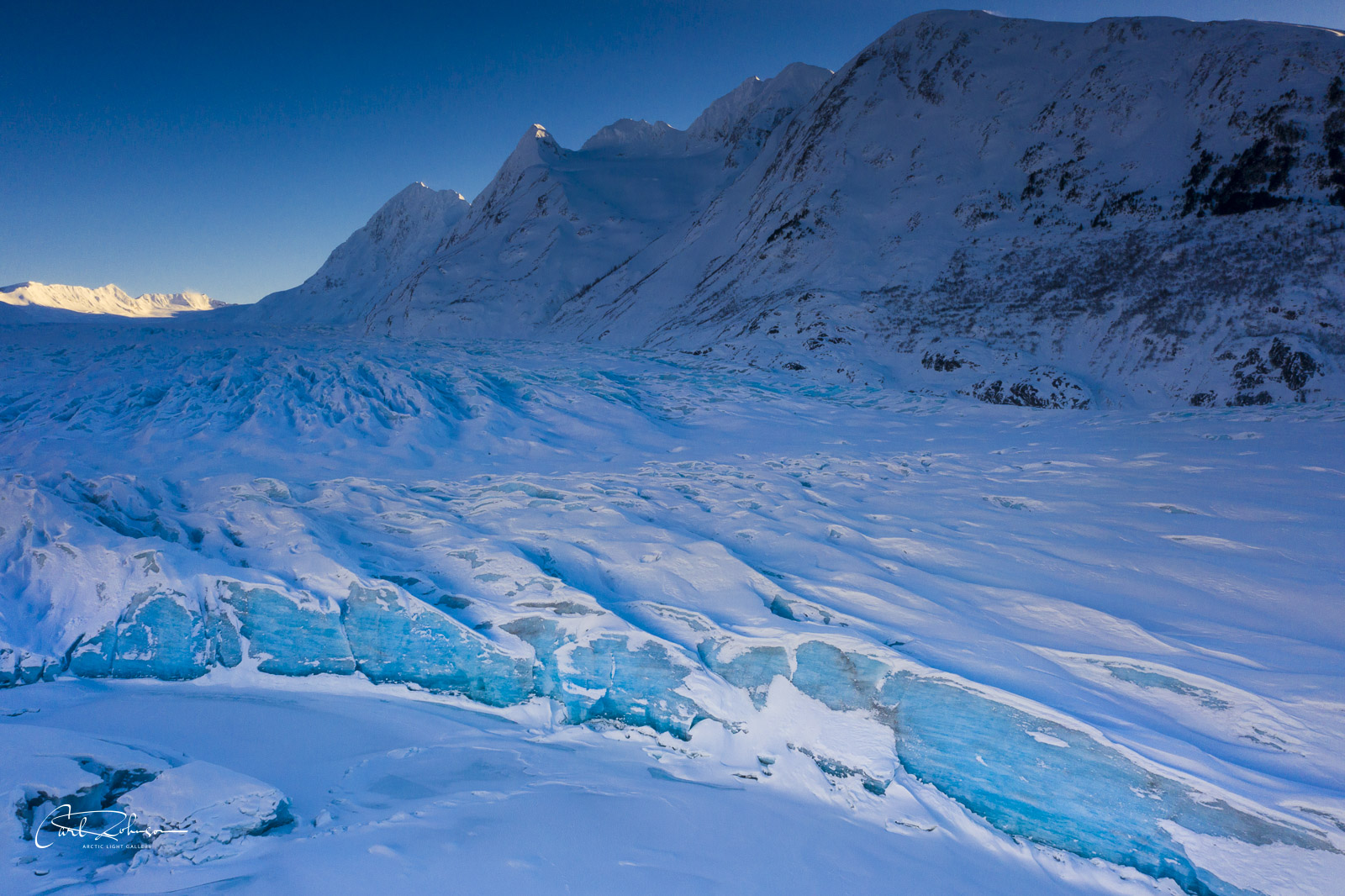 The toe, or edge, of the Spencer Glacier turns a deep blue in the shade as the sun drops low on the horizon.