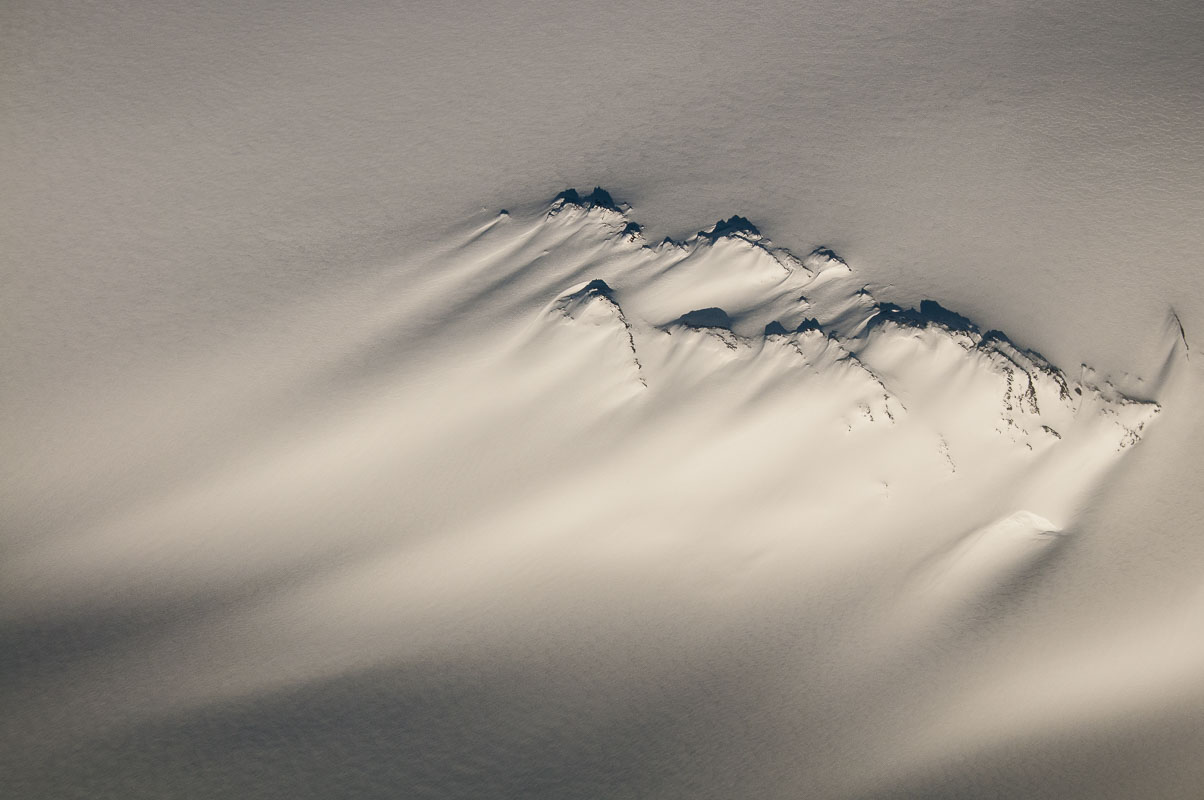 A nunatak is an isolated peak of rock projecting above a surface of inland ice or snow. I did not even know that they existed...