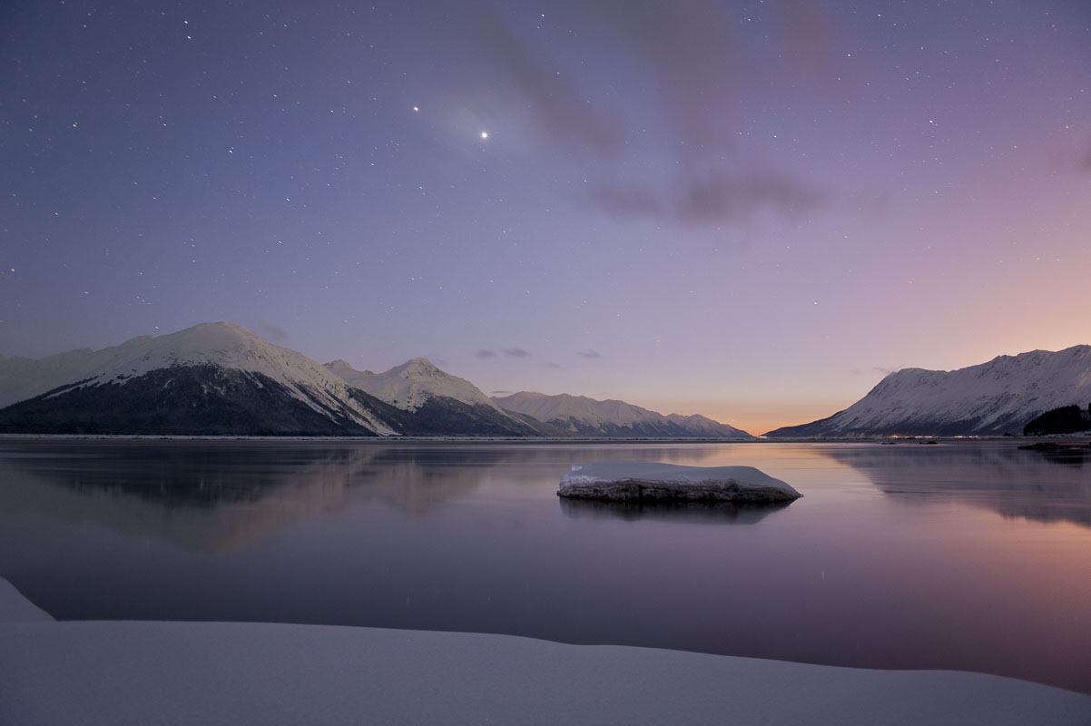 Venus and Jupiter shine brightly in the sky to the west as twilight settles over the calm waters of Turnagain Arm.