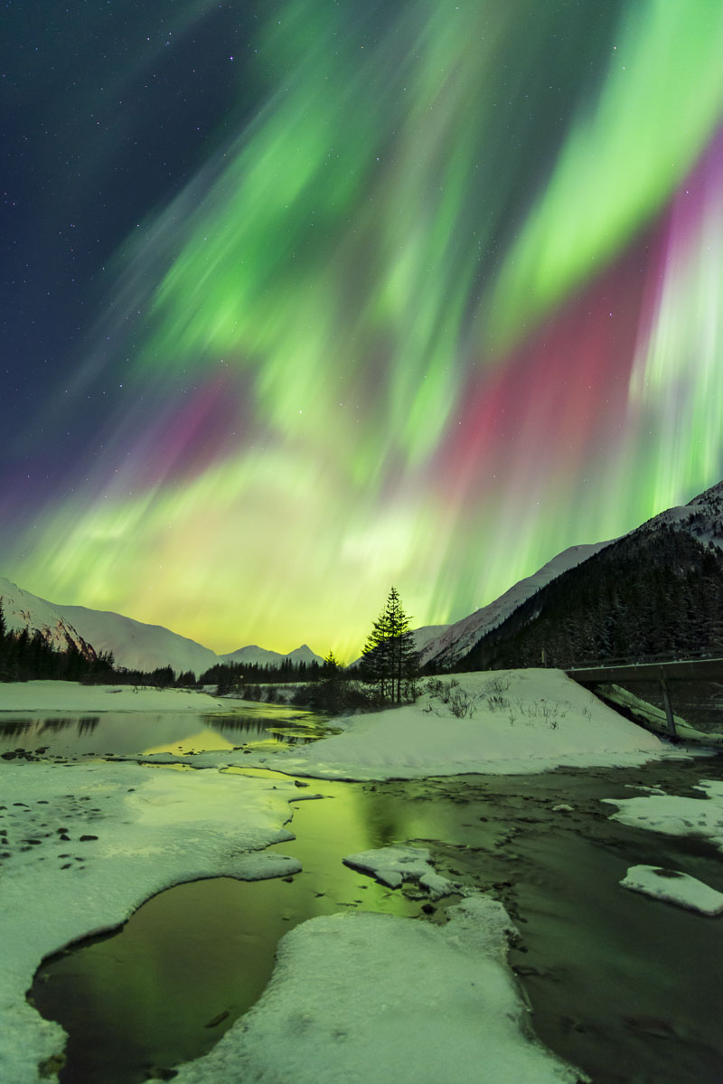 Vibrant colors from an active storm fill the sky over Portage Creek with aurora borealis during the 2013 St. Patrick's Day.