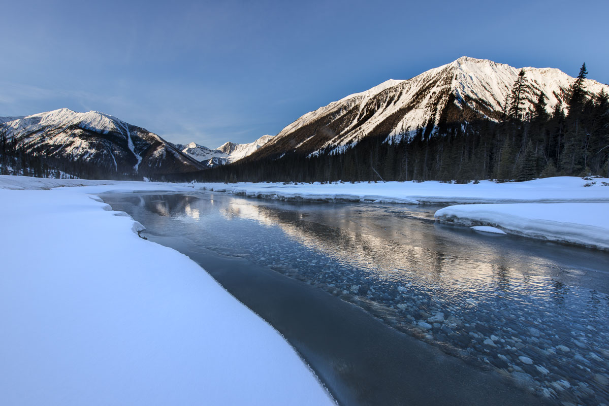 Morning light reflects on ice and open water in the Kootenay National Park, Alberta, Canada.