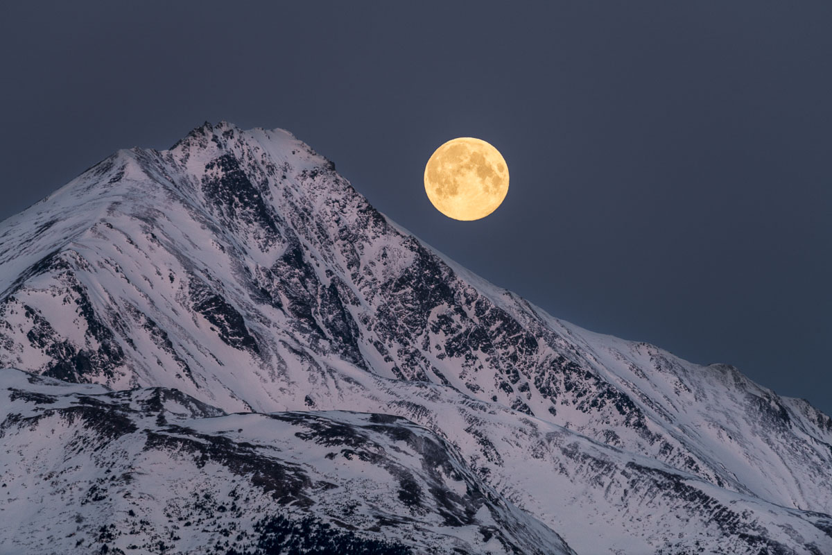 A full moon seems to slide along a ridge in the Kenai Mountains as it works its way to setting shortly before sunrise. Turnagain...
