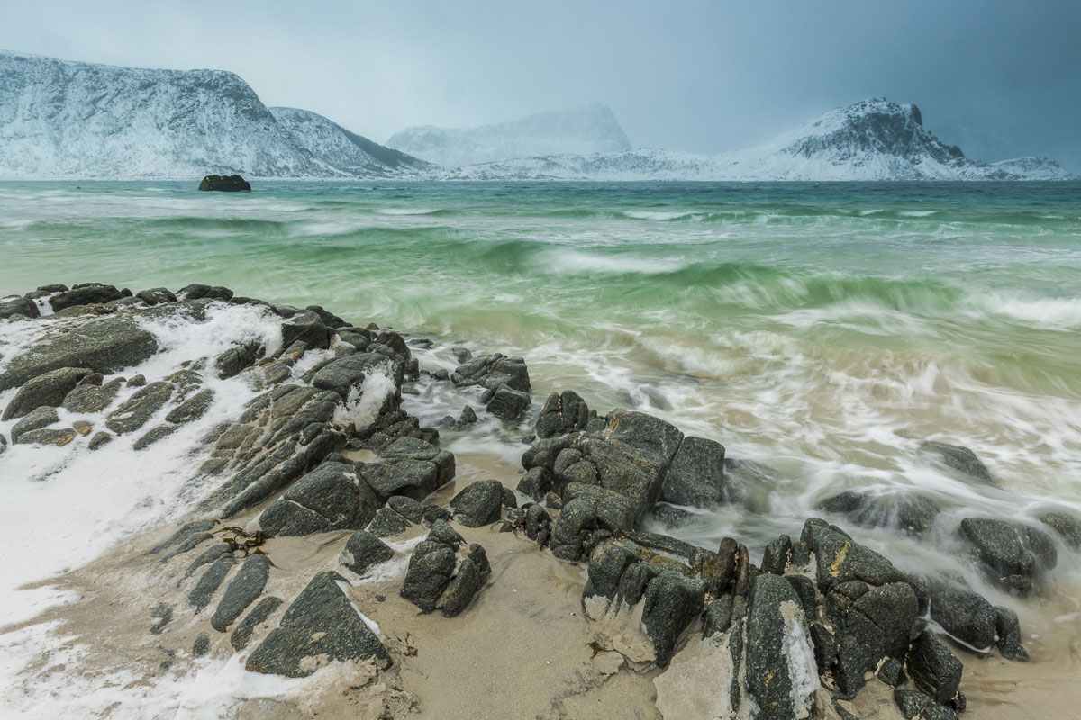 A winter storm sends green surf pounding on the shores of Haukland Beach in the Lofoten Islands, Norway.