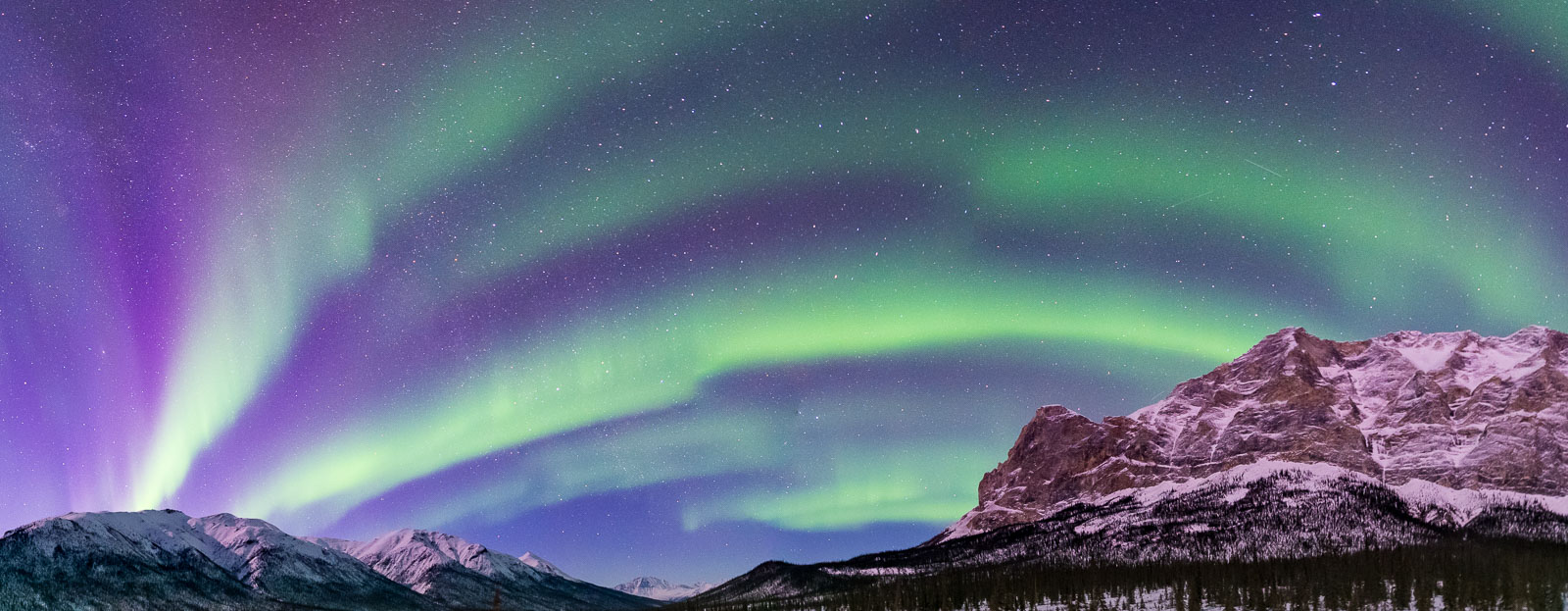 A seven-image stitch panoramic image of the aurora borealis spans across the Middle Fork Koyukuk River valley, with Mt. Sukakpak...