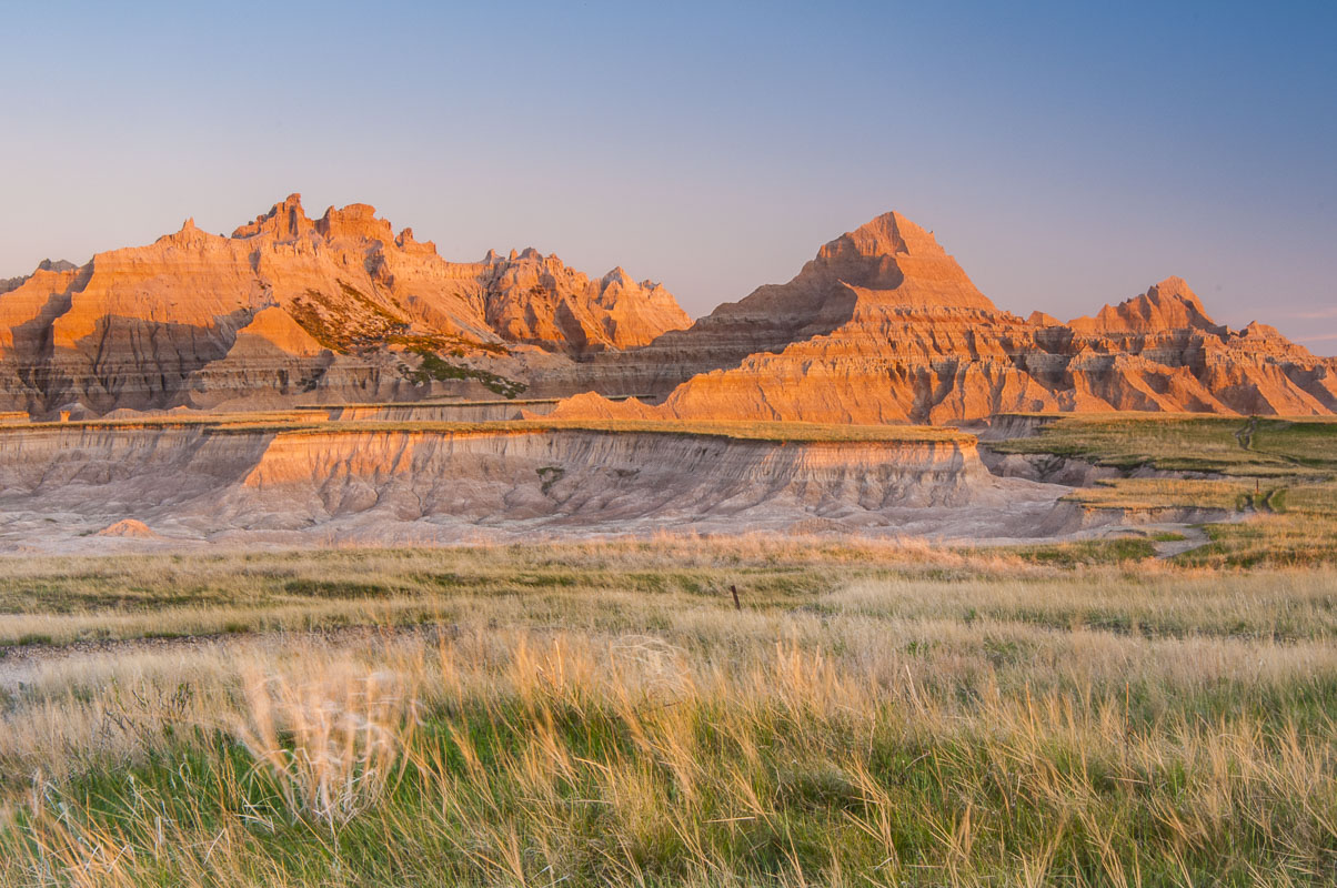 Morning light glows on the north side of formations in the Cedar Pass area of the North Unit, Badlands National Park, South Dakota...