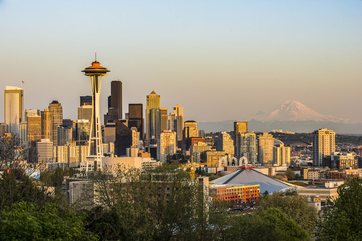 Downtown Seattle in evening light with Mt. Rainier in the background. The Space Needle is painted orange to celebrate its 50th...