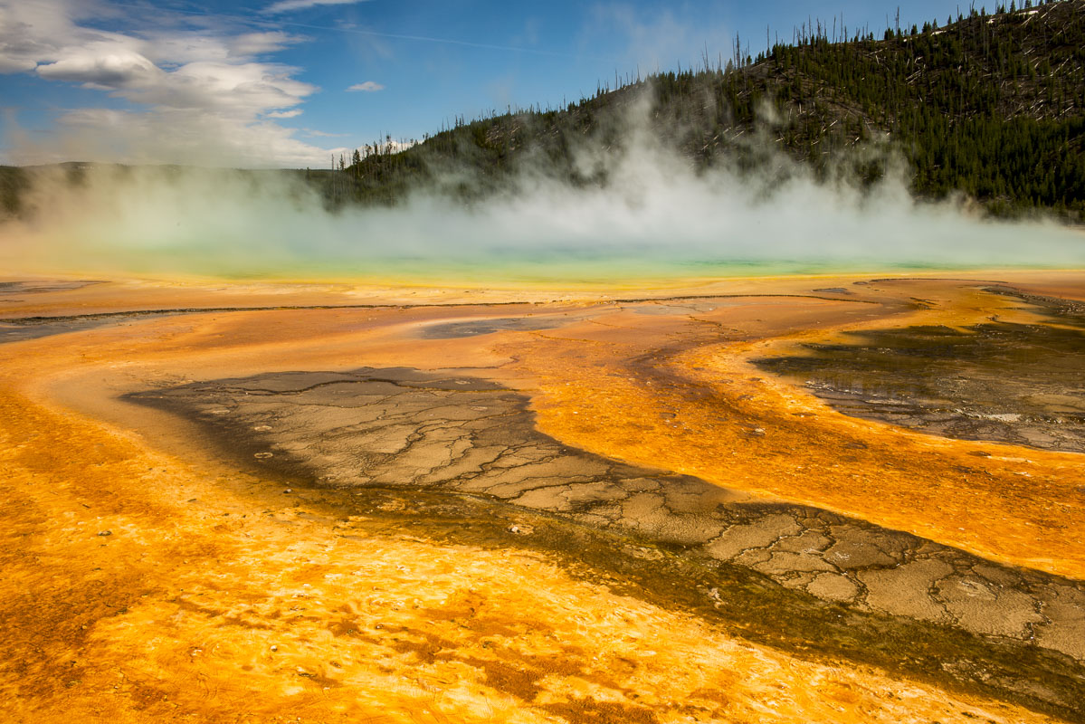 Steam rises from the Grand Prismatic Spring in Yellowstone National Park, Wyoming. The angle of the sun provides the opportunity...