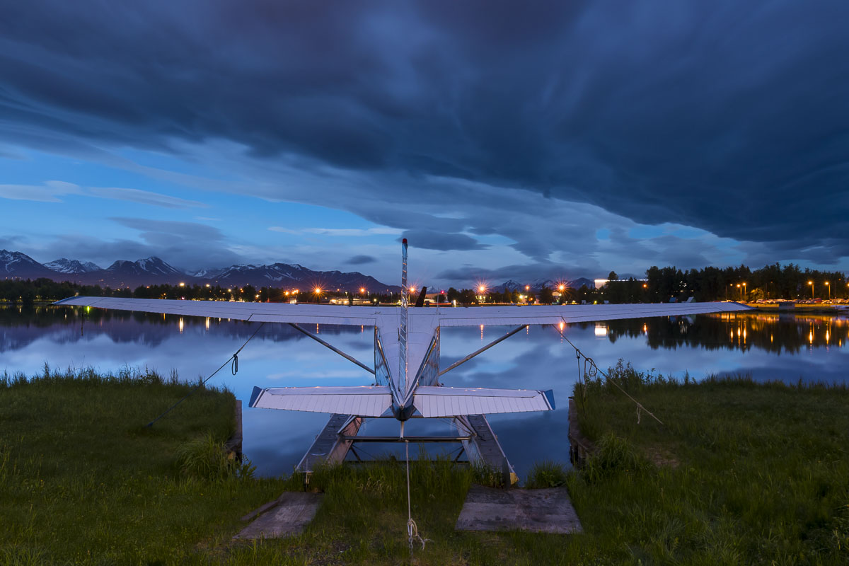 A summer storm fills the sky with dark clouds over a float plane at the Lake Hood Seaplane Base in Anchorage.