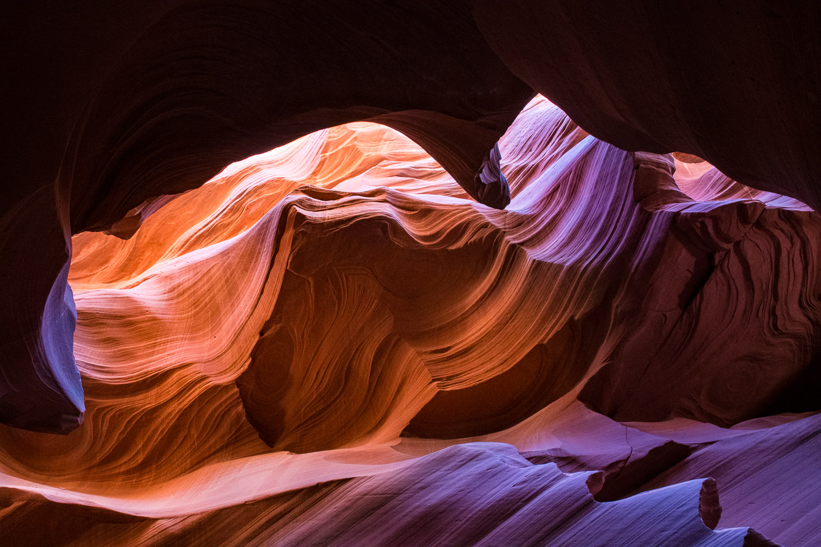 Layers of folding and swirling sandstone catch reflected light from above, accenting textures and painting the stone with different...