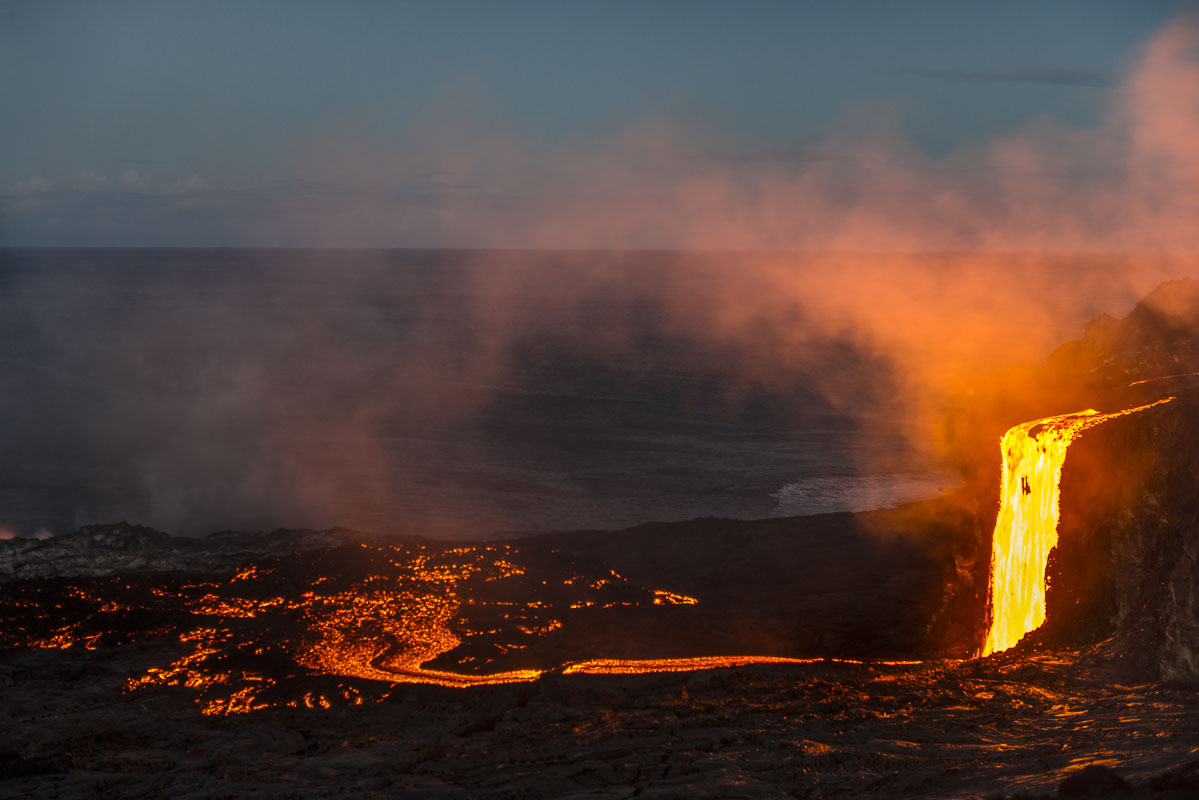 A lava fall spills off the edge of the Hawaii coast, spreading its way toward the ocean in Hawaii Volcanoes National Park.