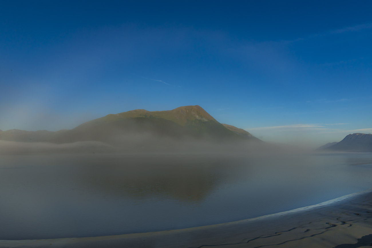 A fogbow, or white rainbow, appears on a calm morning in thin fog along the Turnagain Arm.