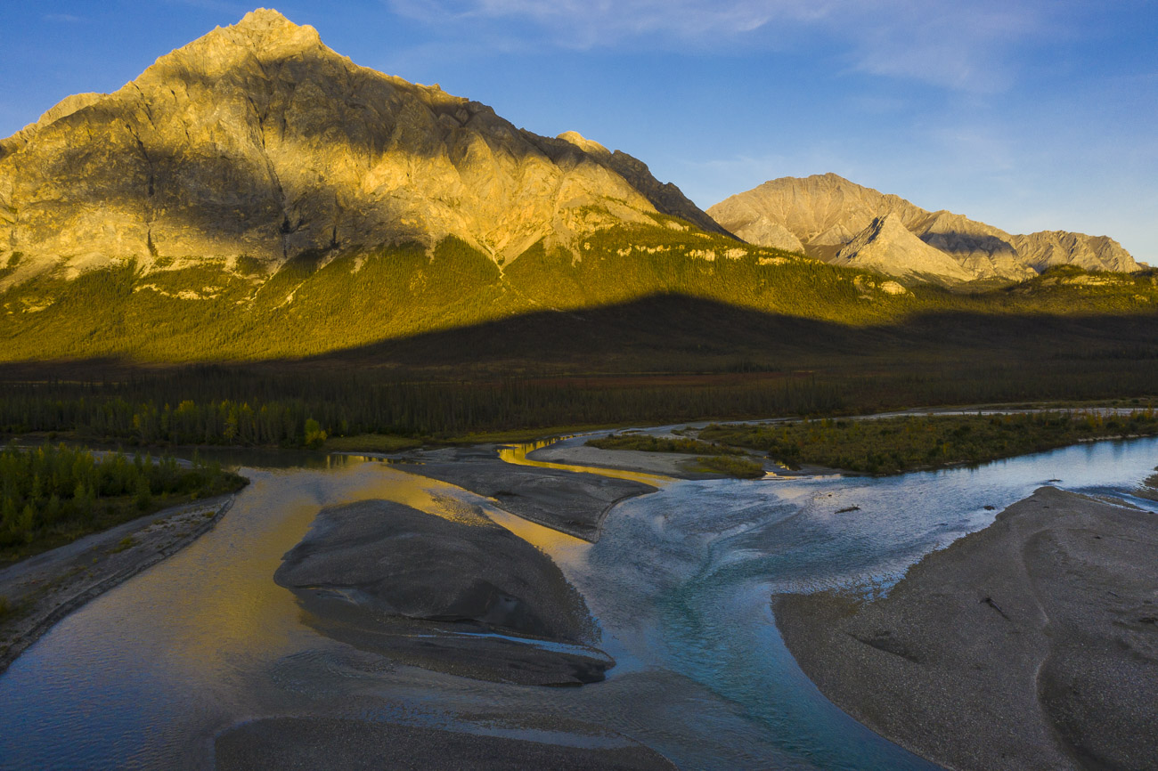 Mt. Dillon catches shafts of evening light, reflecting some color onto the waters of the Dietrich River. Wiehl Mountain looms...
