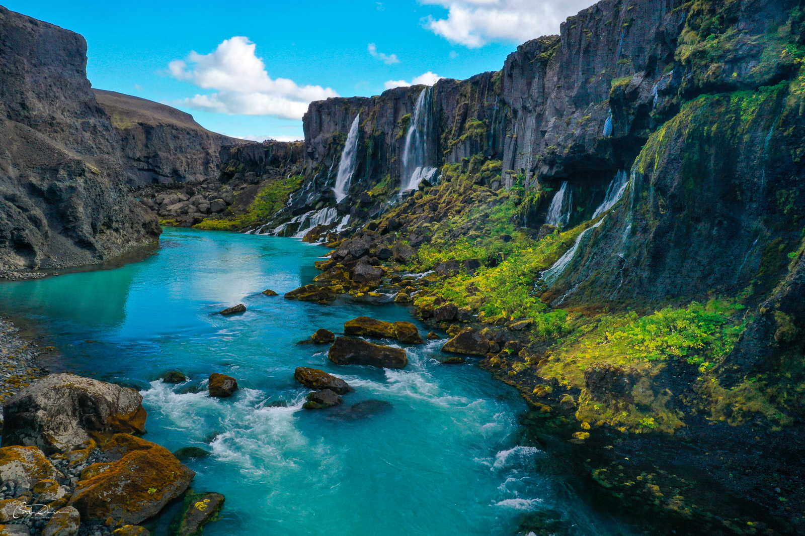A series of waterfalls spill down into a canyon in the Iceland Highlands.
