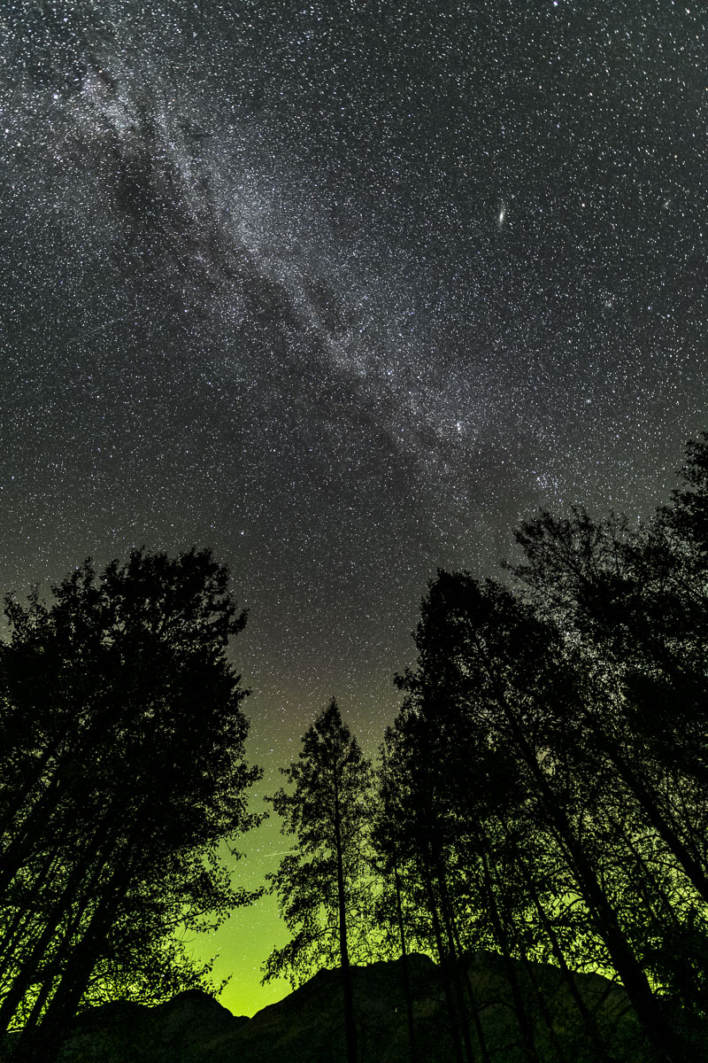 The Milky Way shines in the sky over a quiet aurora in Portage Valley, Chugach National Forest, Alaska.
