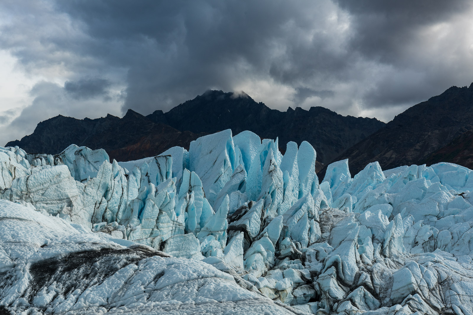 The shape of the "Ice Fall" of Matanuska Glacier perfectly mirrors the shape of a mountain ridge in the background.