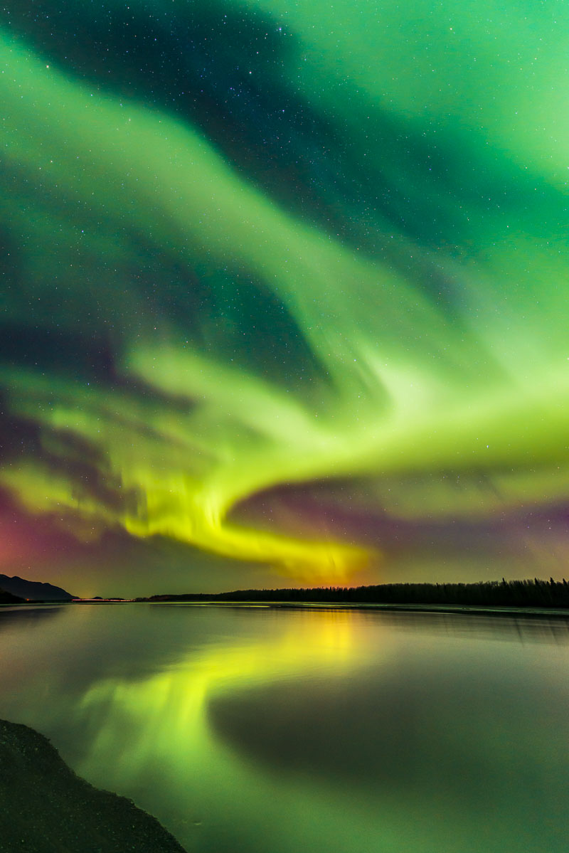A tall aurora borealis display towers over the Knik River in the early hours of October.