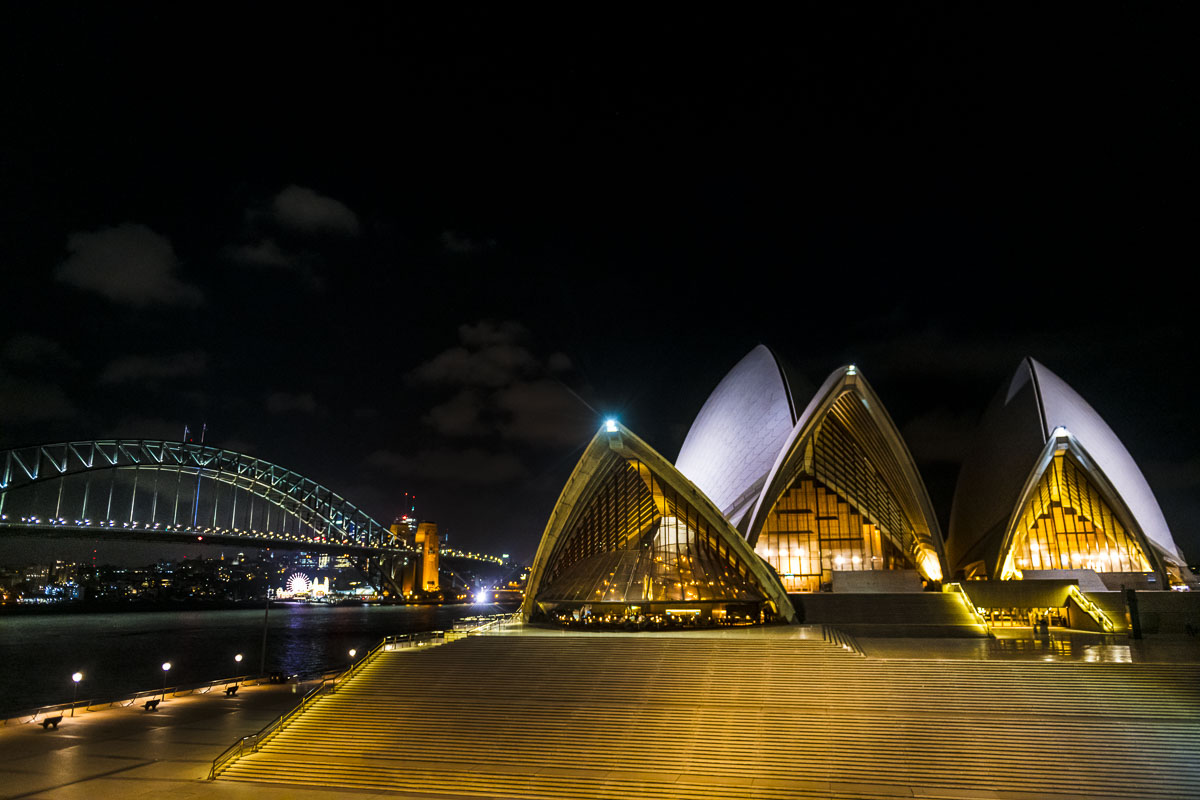The Sydney Opera House stands on its pedestal alongside the waterfront district.