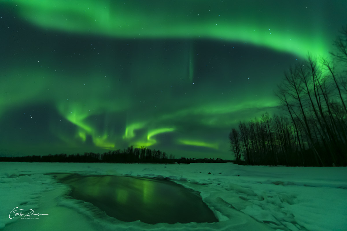 The aurora borealis swirls in the sky over the confluence of the Chulitna, Talkeetna and Susitna Rivers near Talkeetna, Alaska...
