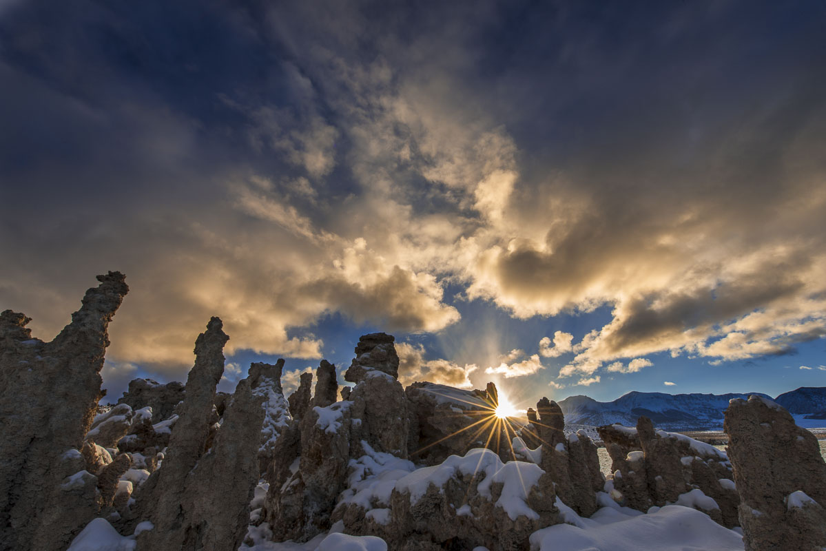 The sun peaks through a cluster of tufa formations at Mono Lake, California, in the evening.