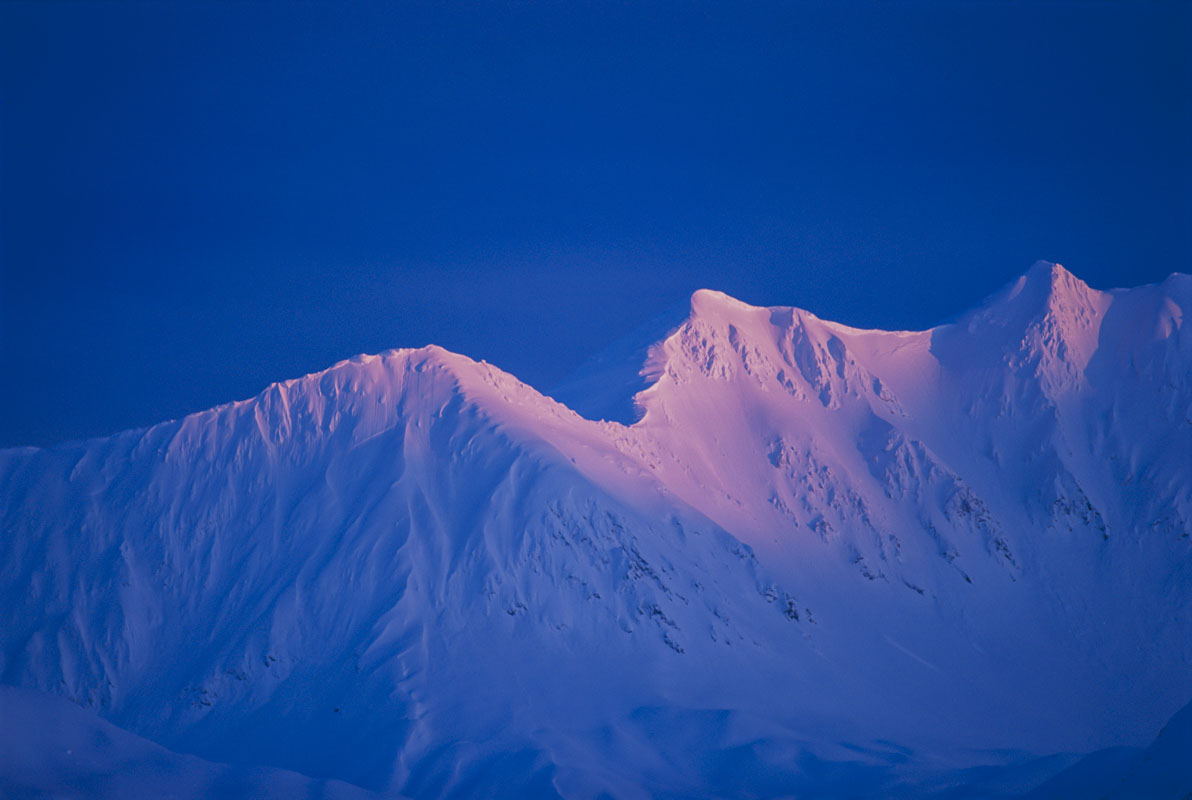 The pink hue of alpenglow on snow-covered mountains is one of the reasons why Iove landscape photography in the Alaskan winter...