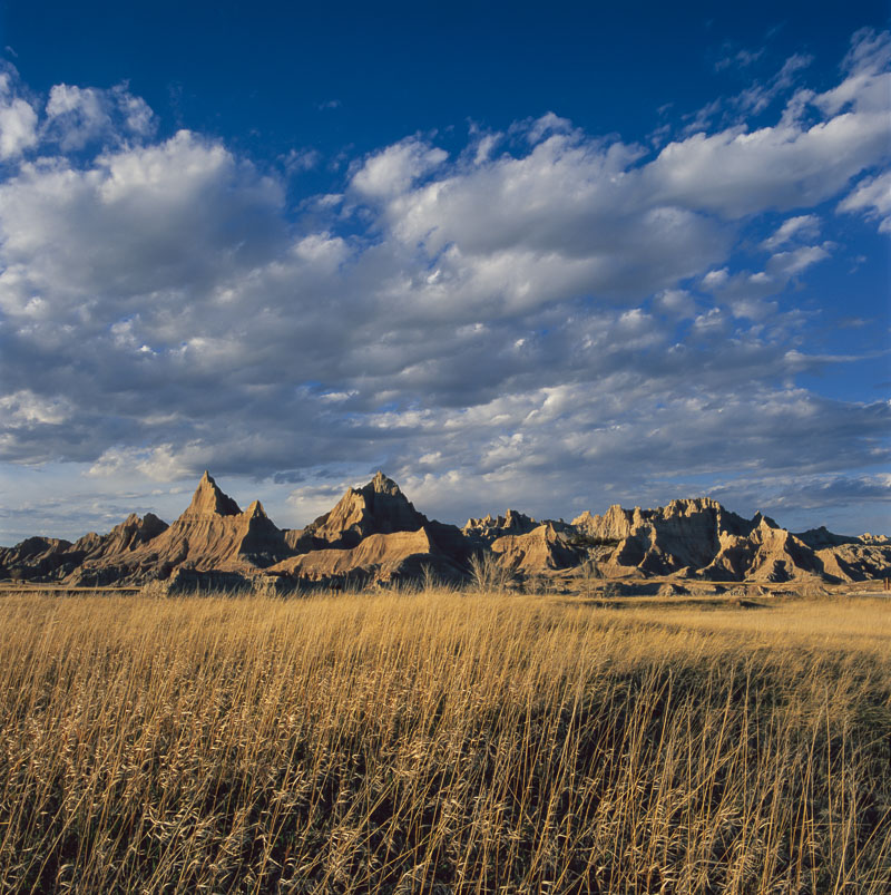 Evening light shines on a series of formations in the North Unit of Badlands National Park, South Dakota. When viewed from a...