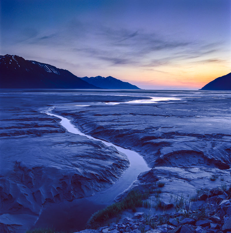 A channel cut throug the mud flats of Turnagain Arm provides a leading line at low tide at around midnight in late June. Tango...